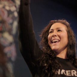 Woman smiling and raising hand in high-five during indoor golf play
