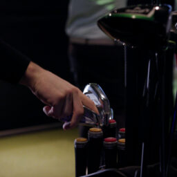 Hand selecting a golf club from a bag inside an indoor golf simulator facility