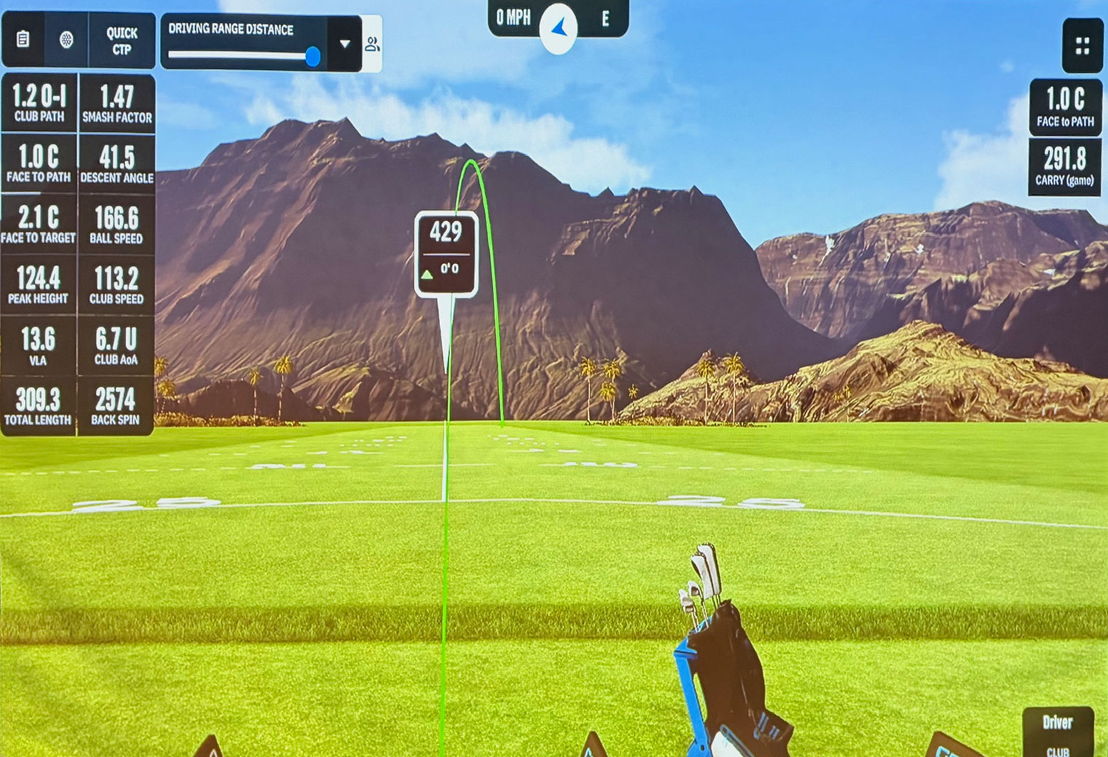 Golf simulator screen showing shot tracking data, ball flight path, and driving range metrics