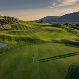 Elevated view of Bighorn Golf Kamloops green and rolling fairway contours with long evening shadows